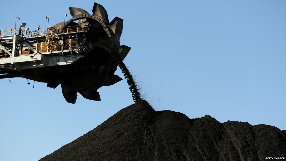 A coal loader hanging over a mound of coal Australia