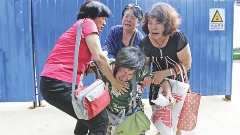 Relative of passengers on missing Malaysia Airlines MH370 react outside the Malaysia Airlines&#039 office in Beijing yesterday