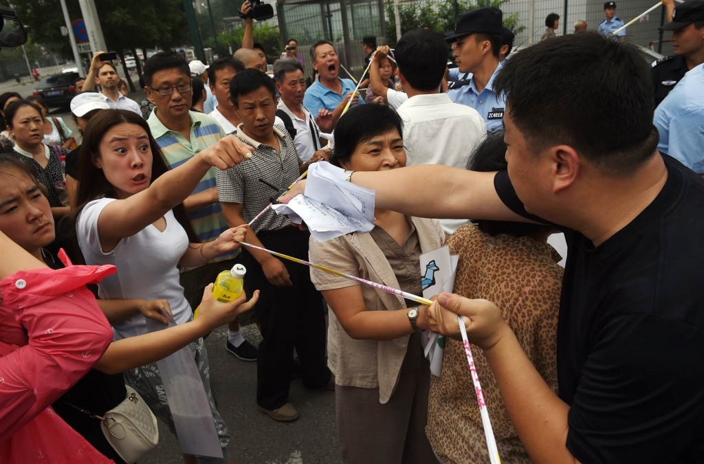 Image Relatives of passengers on missing Malaysia Airlines MH370 argue with police officers