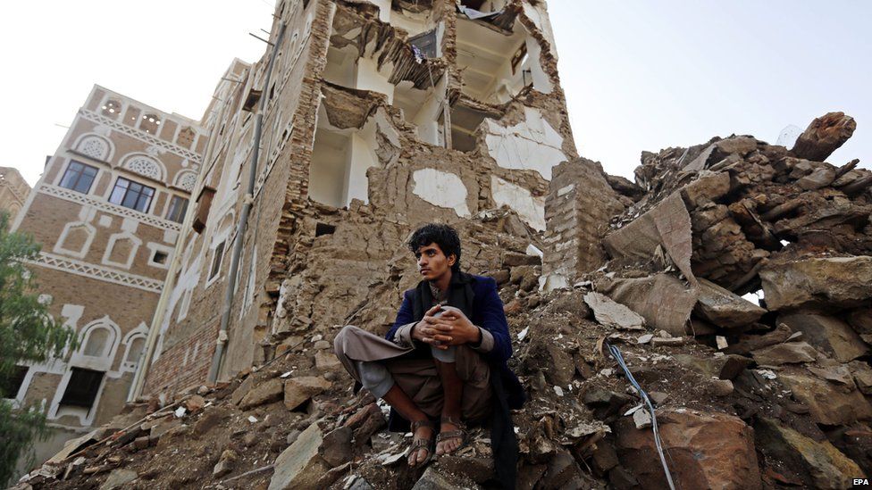 A Yemeni man looks on as a team of the International Committee of the Red Cross delegates inspects the scene of a Saudiled coalition air strike in Sanaa's Old City