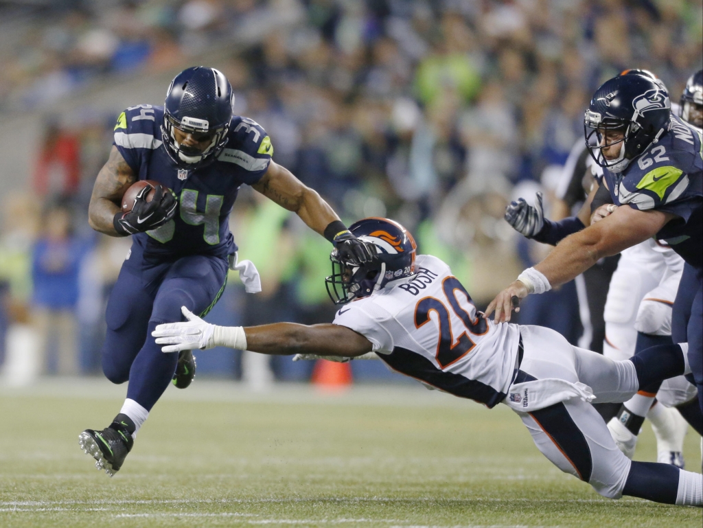 Seattle Seahawks running back Thomas Rawls carries the as Denver Broncos defensive back Josh Bush attempts a tackle in the second half of a preseason NFL football game