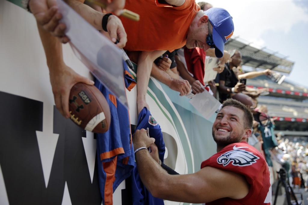 Philadelphia's Tim Tebow signs autographs for fans after practice on Aug. 4 at training camp in Philadelphia. Tebow's throwing motion and mechanics are clearly improved since the last time he threw a pass in an NFL game two years ago. He's wildly popular