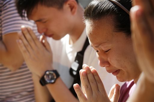 Family members of a bombing victim pray at the Erawan Shrine at Rajprasong intersection in Bangkok Thailand Wednesday Aug. 19 2015. A central Bangkok shrine reopened Wednesday to the public after Monday's bomb blast as authorities searched for a man