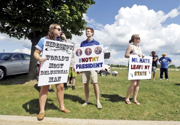 Democratic supporters Hayley Alderman left Sam McNerney center and Julie Haefner stand outside the Birch Run Expo Center before Republican presidential candidate Donald Trump was scheduled to address a GOP fundraising event, in Birch Run Mic