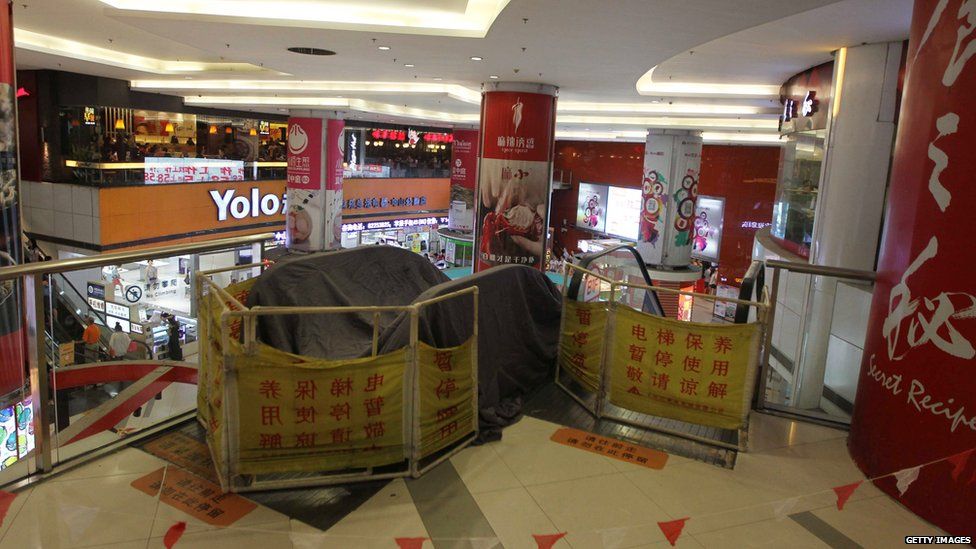 Barriers around escalators where a cleaner's left leg became trapped at a shopping mall