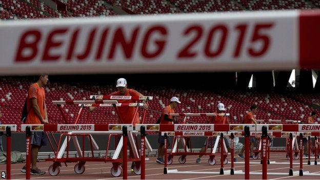 Volunteers put hurdles on the track at the Bird's Nest stadium in Beijing 18