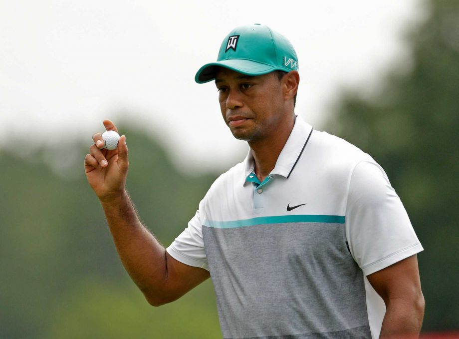 Tiger Woods acknowledges the crowd after finishing his round on the ninth hole during the first round of the Wyndham Championship golf tournament in Greensboro NC