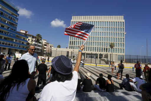 A woman waves a U.S flag in front of the U.S. Interests Section in Havana Cuba