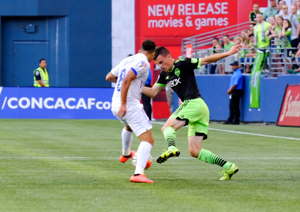 Seattle midfielder Aaron Kovar makes a move on CD Olimpia's Arnold Peralta