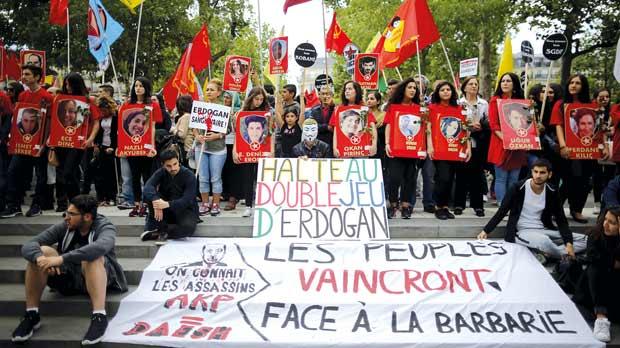 Members of the Kurdish community in France hold posters depicting victims of Monday’s bomb attack in Suruc Turkey during a demonstration in Paris. A suspected Islamic State suicide bomber killed 32 people last week in the town of Suruc close to the Sy