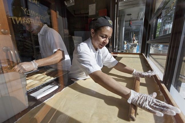 Fatima Godoy rolls out the dough as Gustavo Servellon left applies the sprinkles as they construct pastries in the bay window at Ted’s Bulletin a Capitol Hill restaurant in Washington. The Labor Department rele