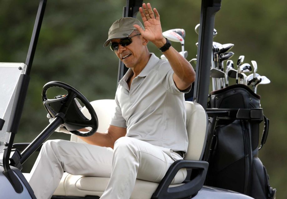 President Barack Obama waves to people from his golf cart while golfing Saturday Aug. 8 2015 at Farm Neck Golf Club in Oak Bluffs Mass. on the island of Martha's Vineyard. Obama is spending his first full day of vacation on the island playing golf