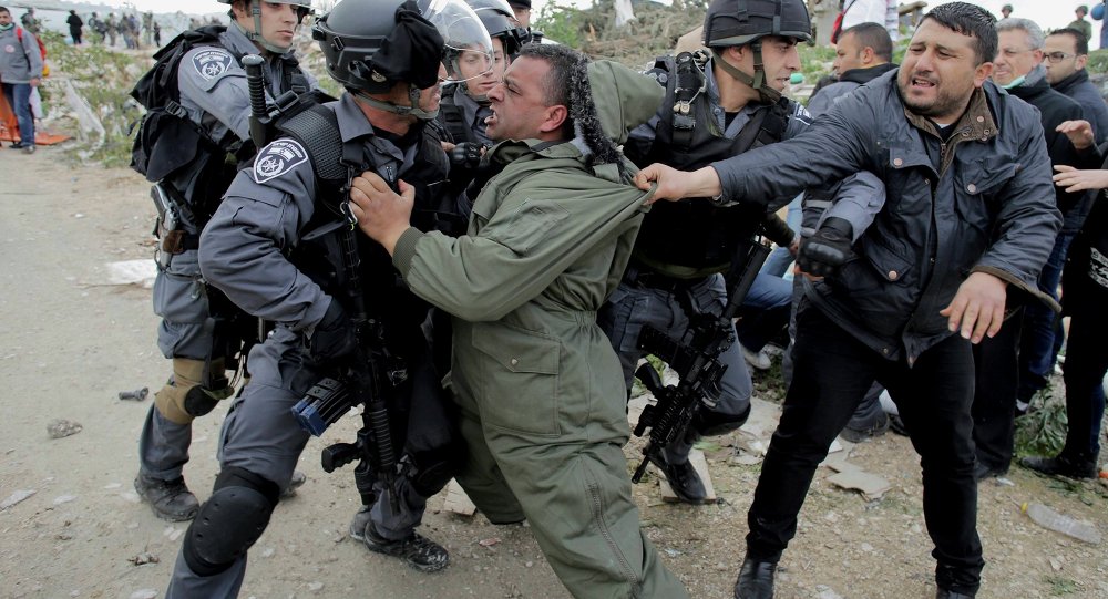 A Palestinian man scuffles with Israeli border policemen as they clear a protest on land that Palestinians said was confiscated by Israel for Jewish settlements near the West Bank town of Abu Dis near Jerusalem