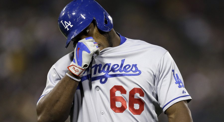 Los Angeles Dodgers&#39 Yasiel Puig wipes his face after hitting a fly out against the Oakland Athletics in the sixth inning of a baseball game