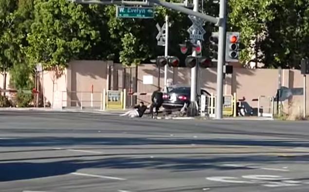 An officer drags a driver to safety