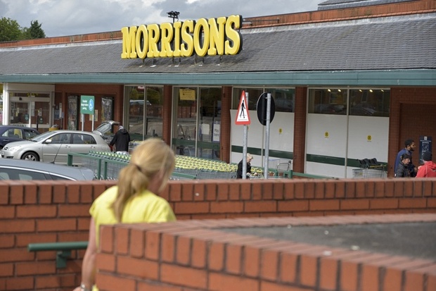 A person walking towards a Morrisons supermarket in Manchester