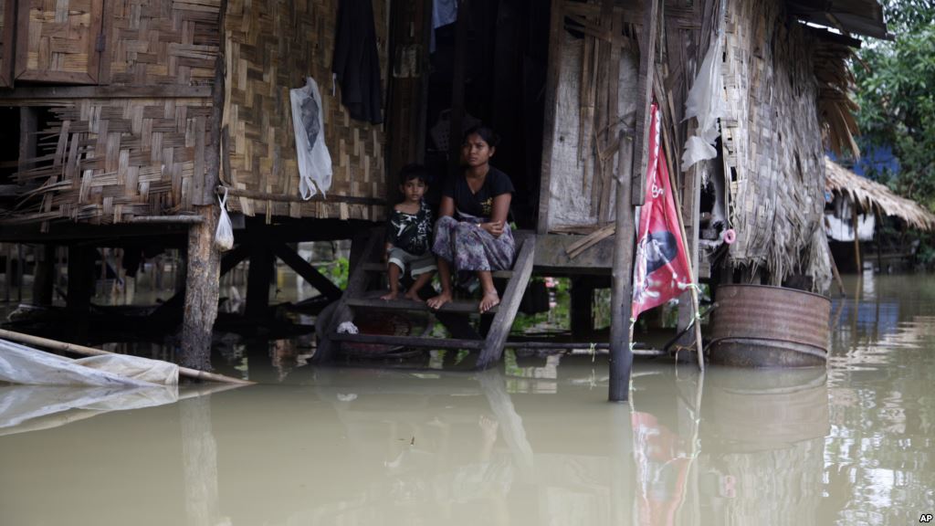 A woman and her child look out from their residence half-submerged in floodwaters in Bago Myanmar Aug 1 2015