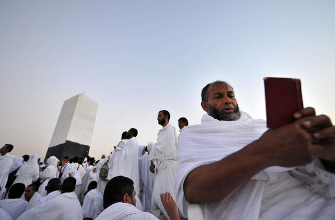 A Muslim pilgrim reads the Quran on top of Mount Arafat in Mecca ahead of the Hajj pilgrimage