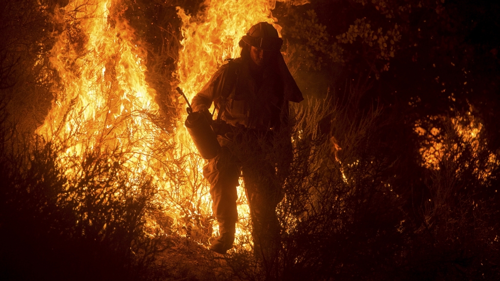 A firefighter lights a backfire while battling the Butte fire near San Andreas California on Saturday