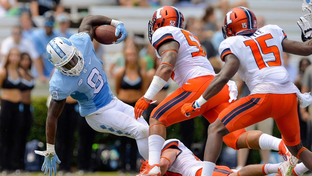 T.J. Logan #8 of the North Carolina Tar Heels spins out of a tackle by B.J. Bello #10 of the Illinois Fighting Illini during their game at Kenan Stadium