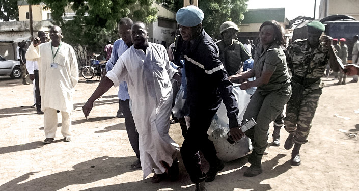 Security forces transport with a blanket the remains of some of the eleven victims of a double blast in the northern Cameroonian city of Maroua