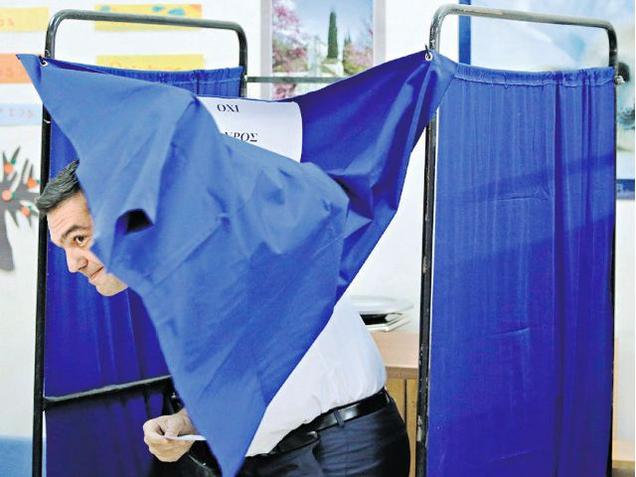 Syriza party leader and ex Greek PM Alexis Tsipras exits a voting booth in Athens on Sunday