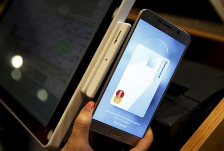 An employee demonstrates a Samsung Pay Samsung's new mobile payment system at a shop in Seoul