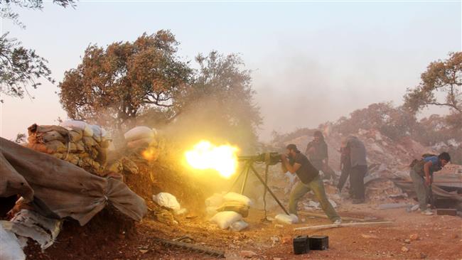 A Takfiri militant fires a heavy machine gun during clashes with government forces on the outskirts of Syria's northwestern Idlib province