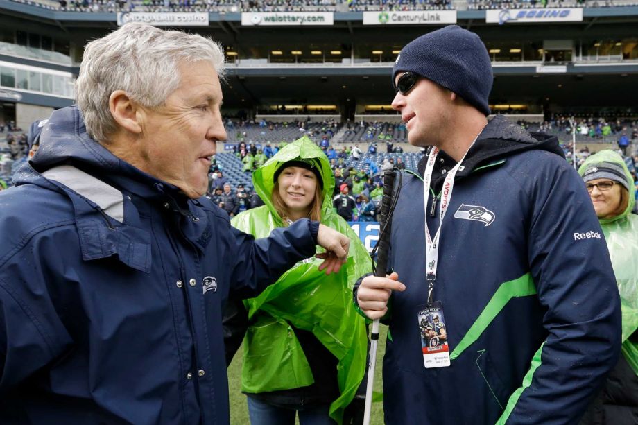 Seattle Seahawks head coach Pete Carroll left talks with Jake Olson 16 before an NFC divisional playoff NFL football game against the New Orleans Saints in Seattle. Olson a blind football player who is a long