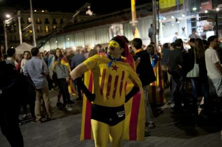 A man dressed as a super hero sporting the Catalan independence standard and a mask celebrates after the partial results of the regional election in Barcelona Spain