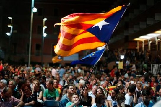 A boy waves a pro-independence Catalan flag known as the Estelada flag and a European flag during a electoral rally for the Catalan regional elections in Barcelona Spain Thursday Sept. 10 2015