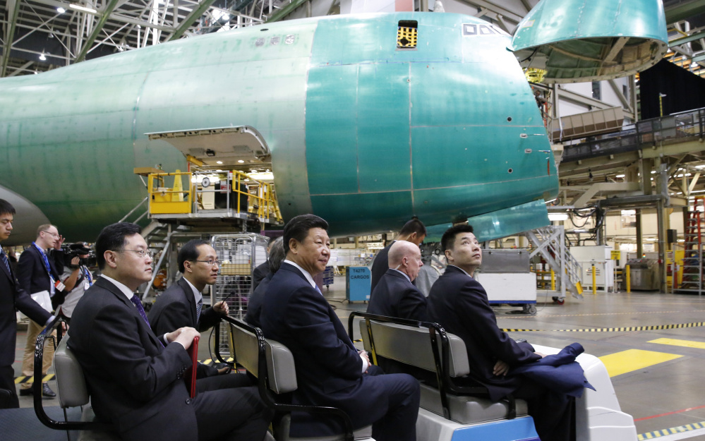 Chinese President Xi Jinping center tours the Boeing assembly line Wednesday in Everett Wash. Boeing said that Chinese companies have agreed to buy 300 jets and build an aircraft assembly plant in China