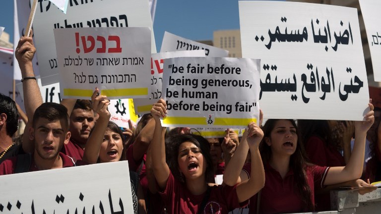 Arab Israeli Christian students hold placards during a protest to demand more funds for Christian schools