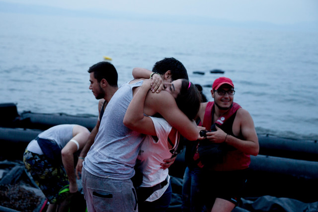 Syrian refugees react as they arrive on the shores of the Greek island of Lesbos after crossing the Aegean Sea from Turkey on a inflatable dinghy, Tuesday Sept. 22