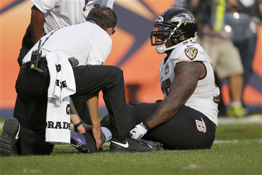 Baltimore Ravens outside linebacker Terrell Suggs is treated on the field during the second half of an NFL football game against the Denver Broncos Sunday Sept. 13 2015 in Denver