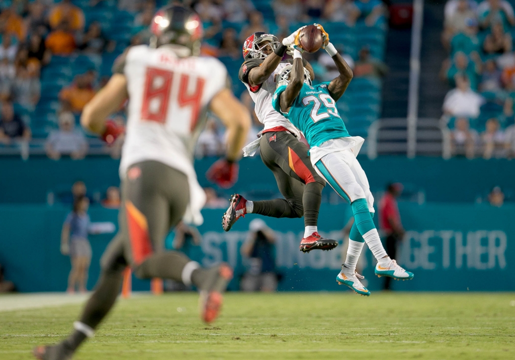 Dolphins safety Will Davis intercepts a pass intended for Tampa Bay receiver Rannell Hall in a preseason game