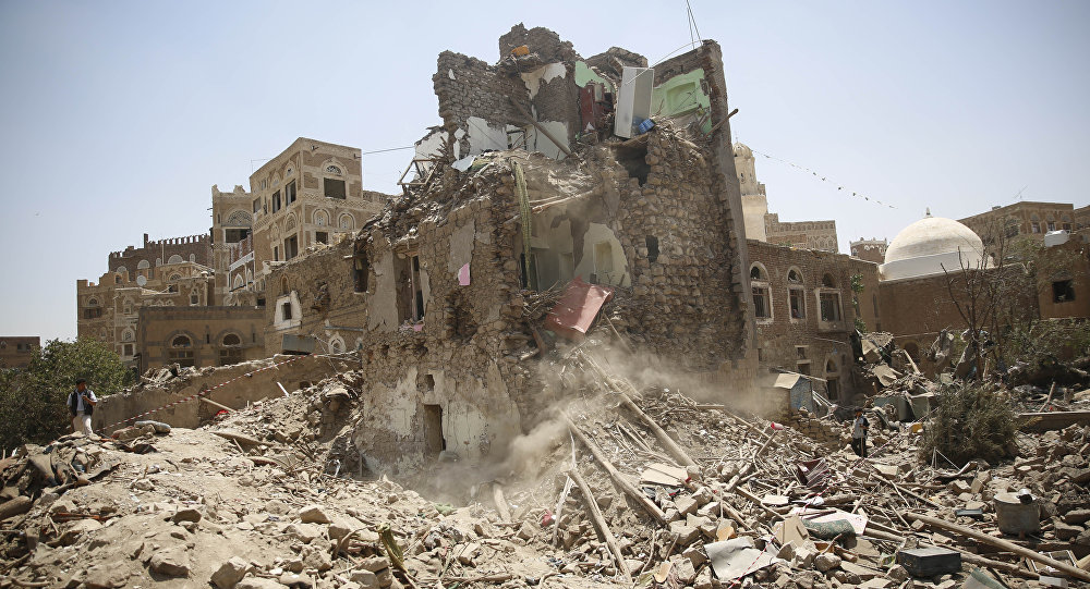 A man left stands guard amid the rubble of a house damaged in a Saudi-led airstrike in Sanaa Yemen Saturday Sept. 19 2015