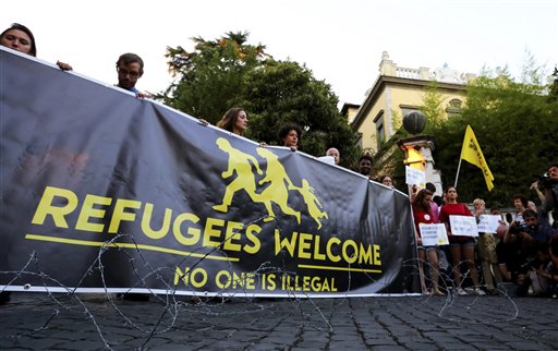 Activists hold a banner reading'Refugees Welcome no one is illegal in front of the Hungarian Embassy in Rome Monday Sept. 21 2015 after the Hungarian government warned migrants not to enter the country as it is a crime punishable by imprisonment. H