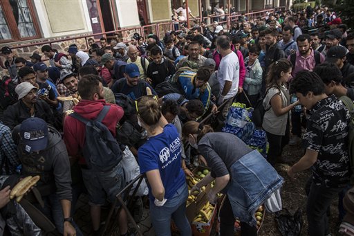 Syrian refugee takes food from volunteers after arriving at the train station in Hegyeshalom Hungary near the border with Austria on Tuesday Sept. 15 2015. Austria's Interior Ministry says temporary border controls with Hungary will be in effect