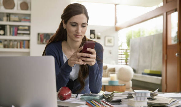 Woman on her phone sitting at her desk