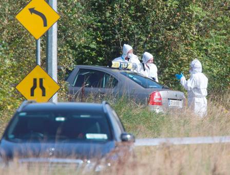 Garda Crime Scene Investigators inspect Mr Mulligan's taxi at the scene of the incident