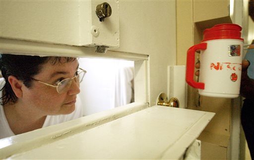 Kelly Renee Gissendaner the only woman on Georgia's death row looks through the slot in her cell door as a guard brings her a cup of ice at Metro State Prison in Atlanta. Georgia state officials have granted