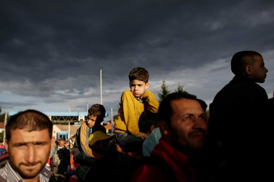 Refugees line up to cross the border from Croatia to the Slovenian village Rigonce at the border station in Harmica Croatia Sunday Sept. 20 2015. The refugees enter a bus for transport to a registration center