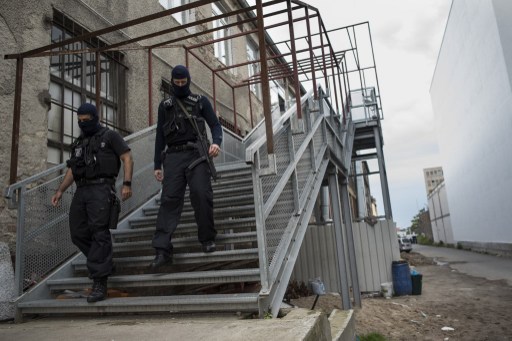 German special police members walk during a raid on a piece of property in Berlin Germany