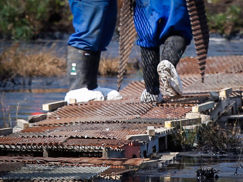 Workers wear protective clothing as the work continues to contain and clean up a pipeline spill at Nexen Energ's Long Lake facility near Fort McMurray Alta. Wednesday