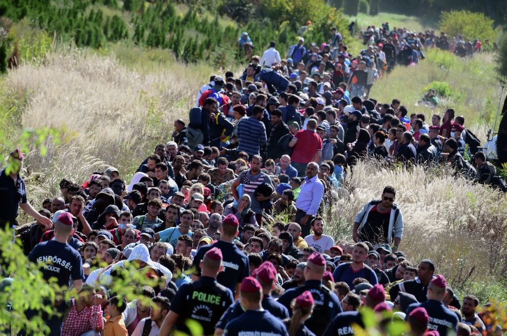 Directed by Hungarian police officers migrants make their way through the countryside after they crossed the Hungarian Croatian border near the village of Zakany in Hungary to continue their trip north