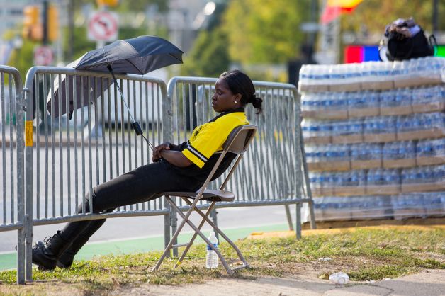 A security guard uses an umbrella to shield herself from the sun while posted on the closed Benjamin Franklin Parkway Thursday Sept. 24 2015 in preparation for a visit from Pope Francis in Philadelphia. W