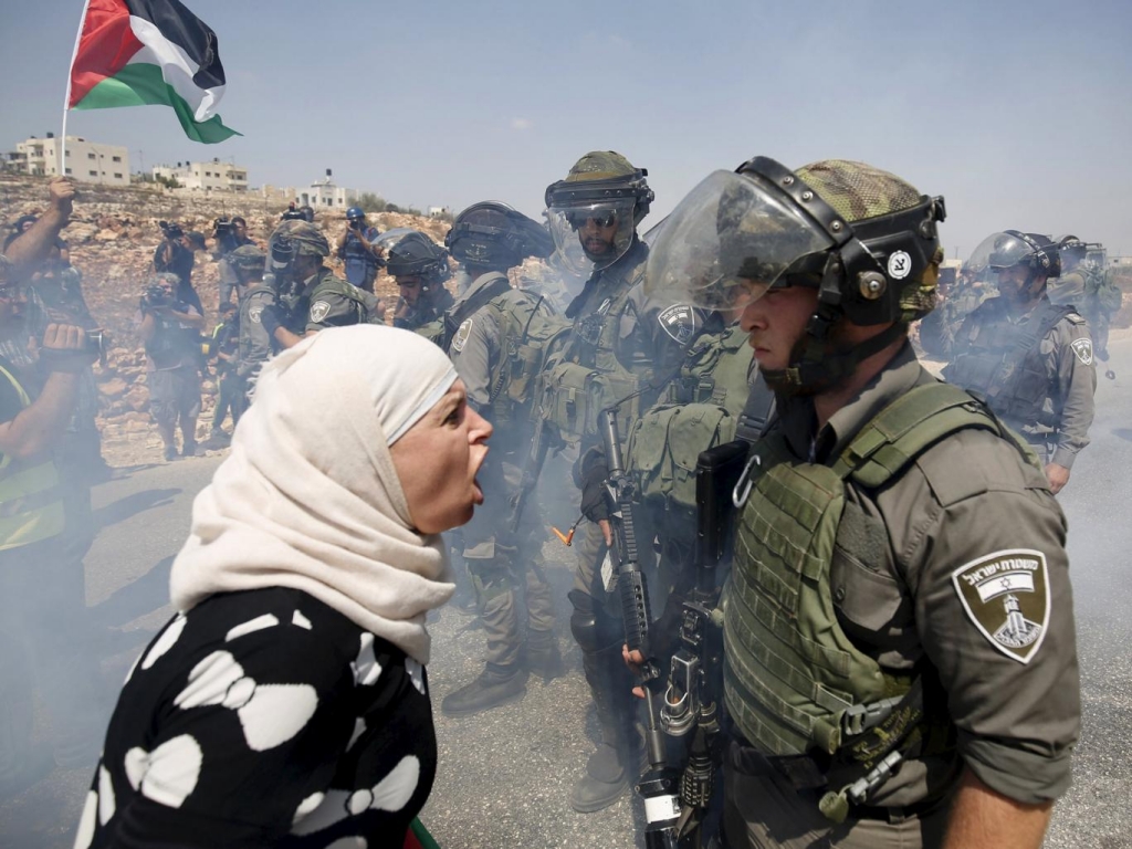 A Palestinian woman argues with an Israeli border policeman during a protest against Jewish settlements in the West Bank village of Nabi Saleh near Ramallah