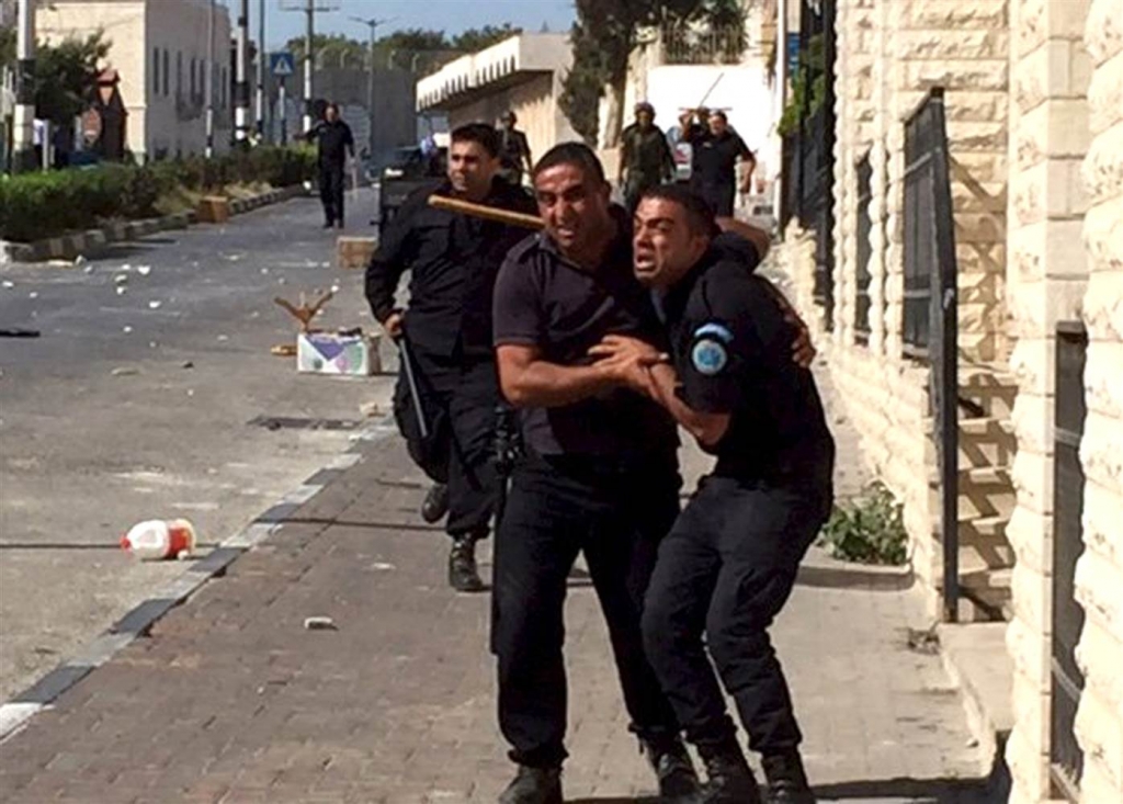 Image A Palestinian policeman reacts next to fellow officers