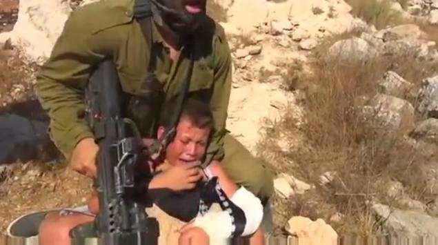 An Israeli soldier was captured on video restraining a young Palestinian protestor after he allegedly threw a rock at the IDF soldiers during a protest in the village of Nabi Saleh Friday